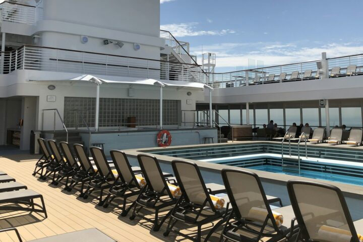 Quiet pool deck with rows of loungers on a cruise ship