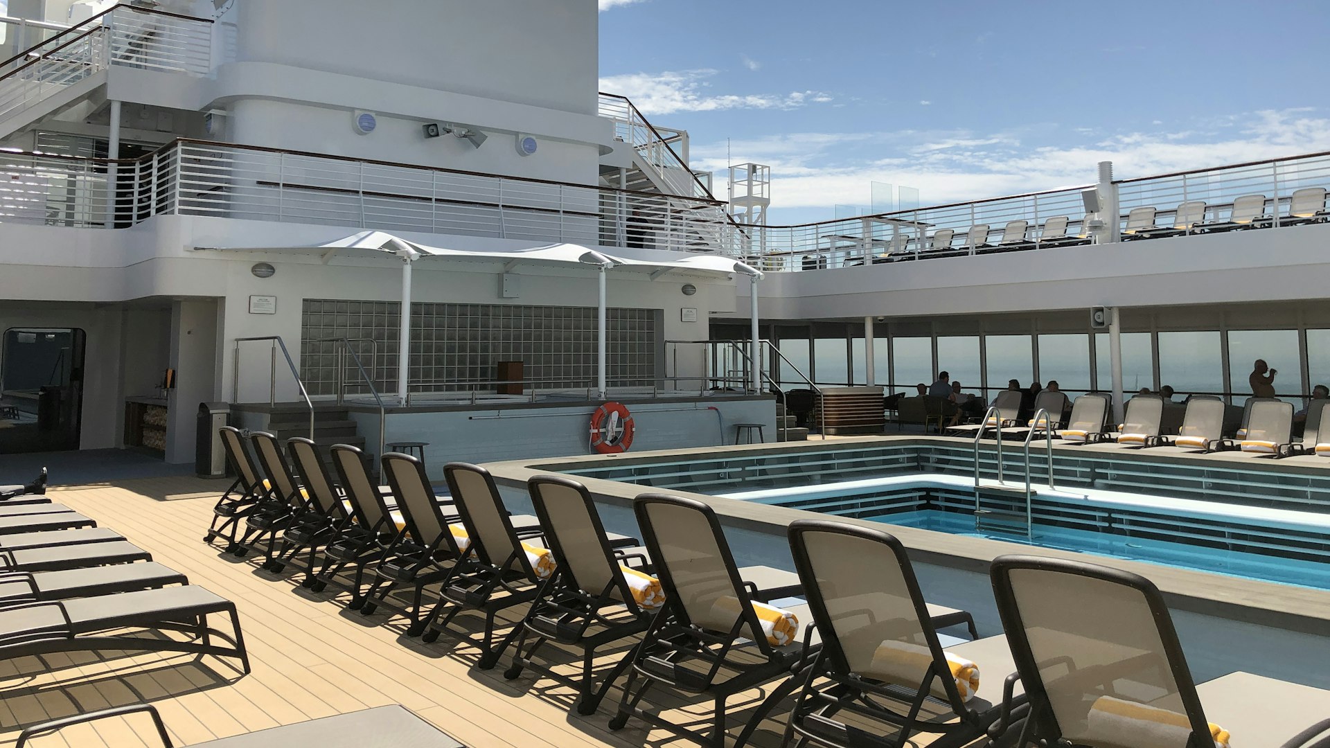 Quiet pool deck with rows of loungers on a cruise ship