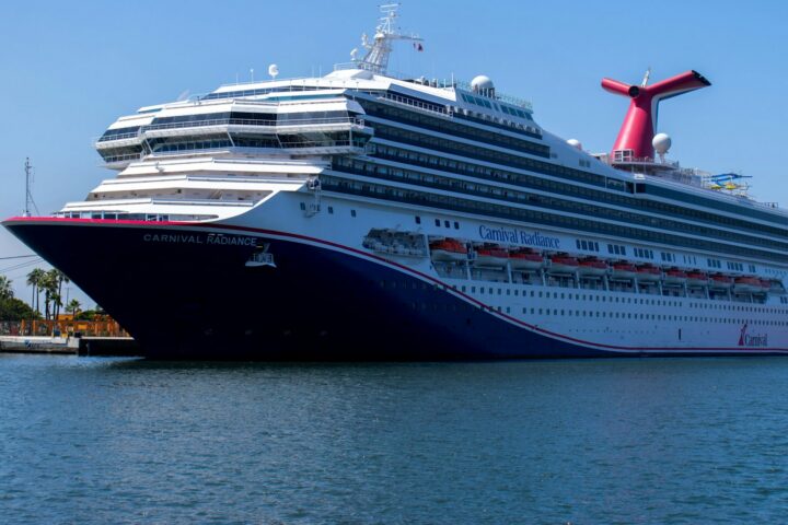 Carnival cruise ship with its red winged funnel docked in port