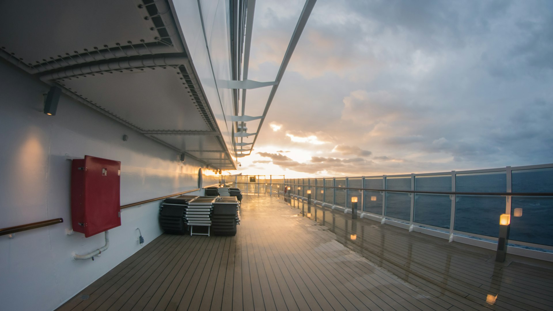 Empty promenade deck on a cruise ship at sunset