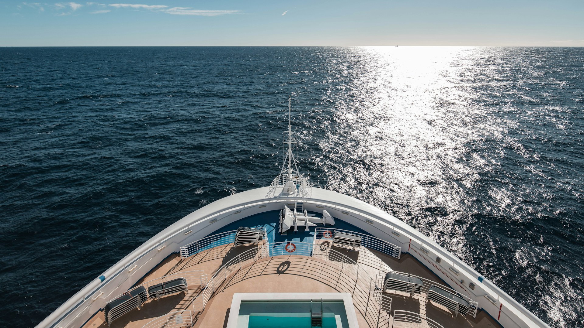 Cruise ship bow heading into sunlight on the open ocean