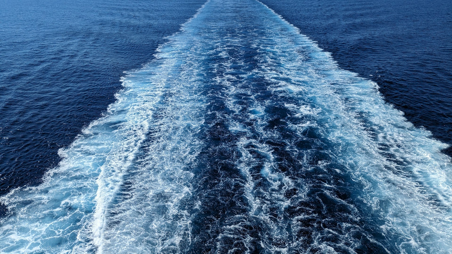 White wake trailing behind a ship on the open ocean
