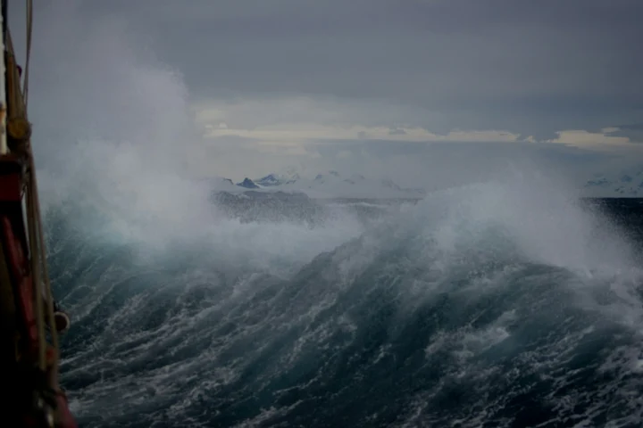 Large waves breaking beside a ship in heavy seas