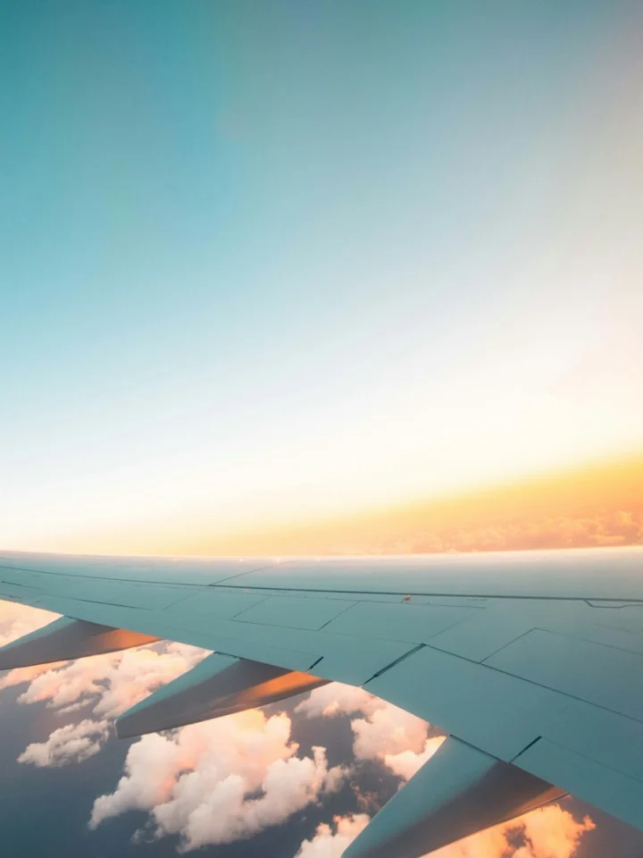 Airplane wing seen through the cabin window at sunset